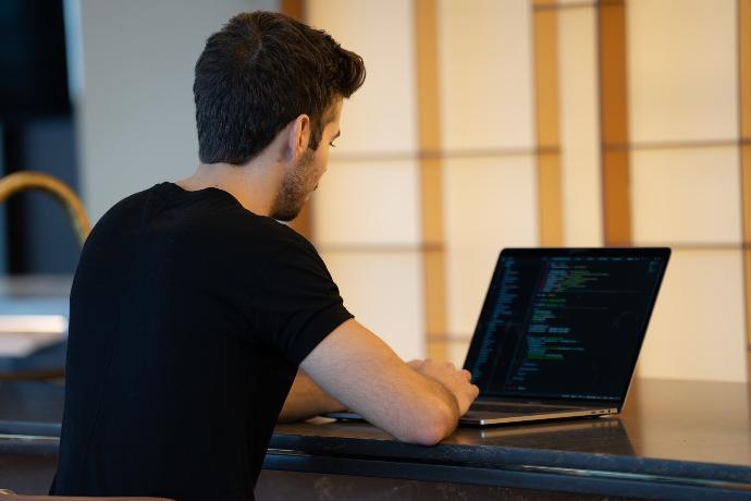 man in black t-shirt using laptop computer